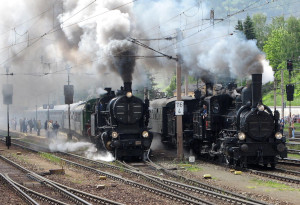 Photographie de deux trains à vapeur sur le quai d'une gare